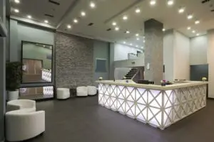 A reception area with white chairs and lights.